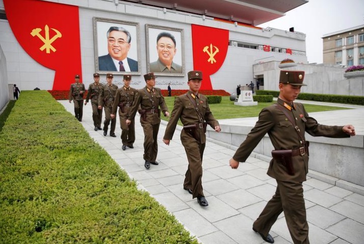 askar korea utara berjalan di hadapan gambar pemerintah