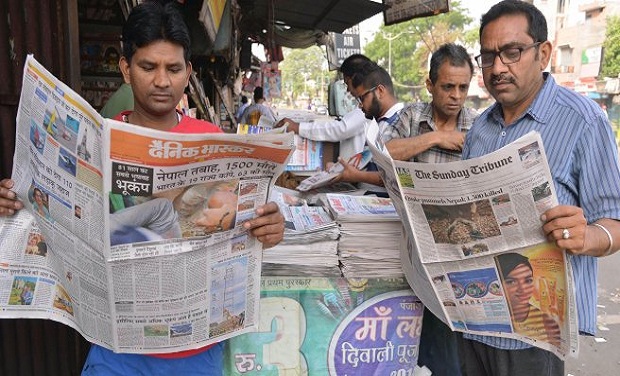 beberapa orang india sedang membaca suratkhabar
