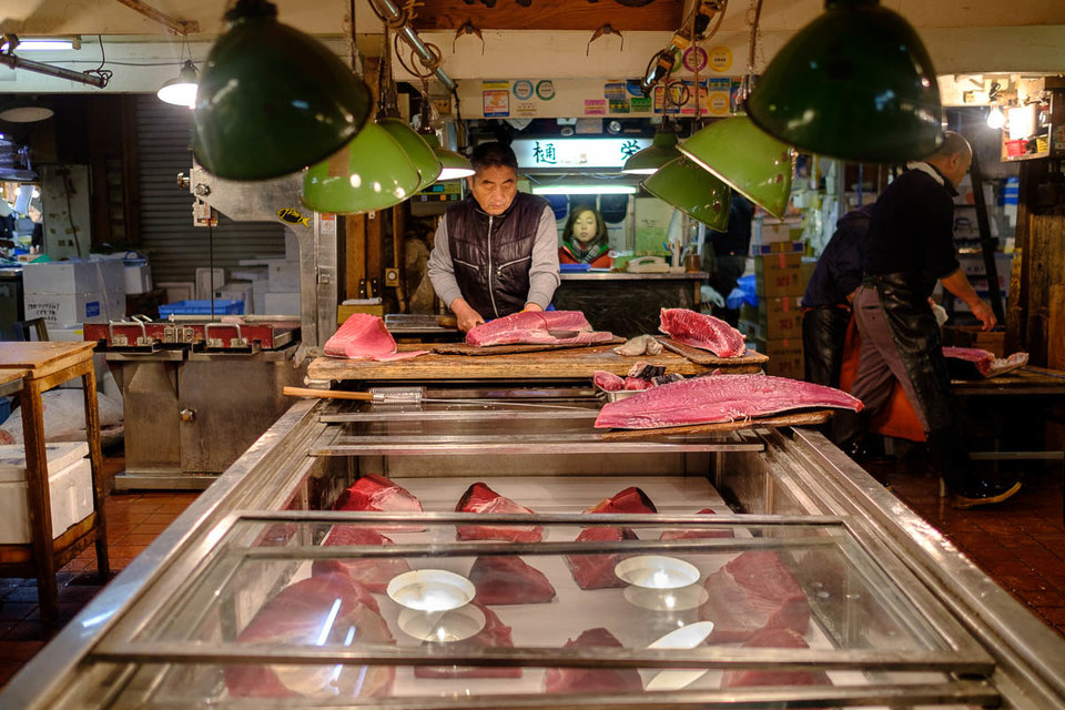 pemborong memotong ikan tuna kepada bahagian lebih kecil untuk dijual kepada restoran sushi