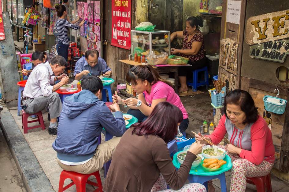 penduduk tempatan menikmati makanan di gerai jalanan