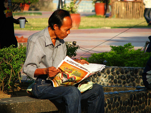 seorang lelaki filipina sedang membaca akhbar