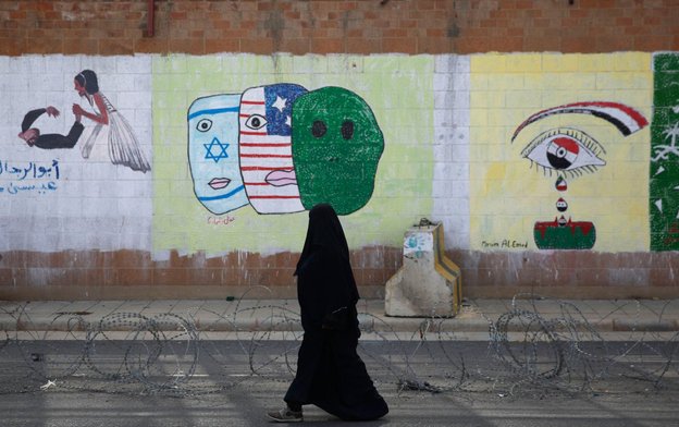 seorang wanita berjalan di depan kedutaan saudi di sanaa yaman