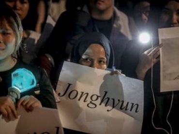 seorang gadis kelihatan memegang placard tertulis jonghyun